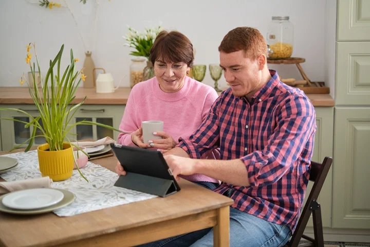 Adult child helping elderly parent book a carer's leave certificate online through OMC Health