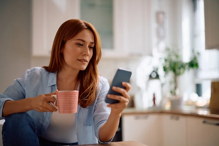 Woman at home using smartphone to request a backdated sick leave certificate through OMC Health