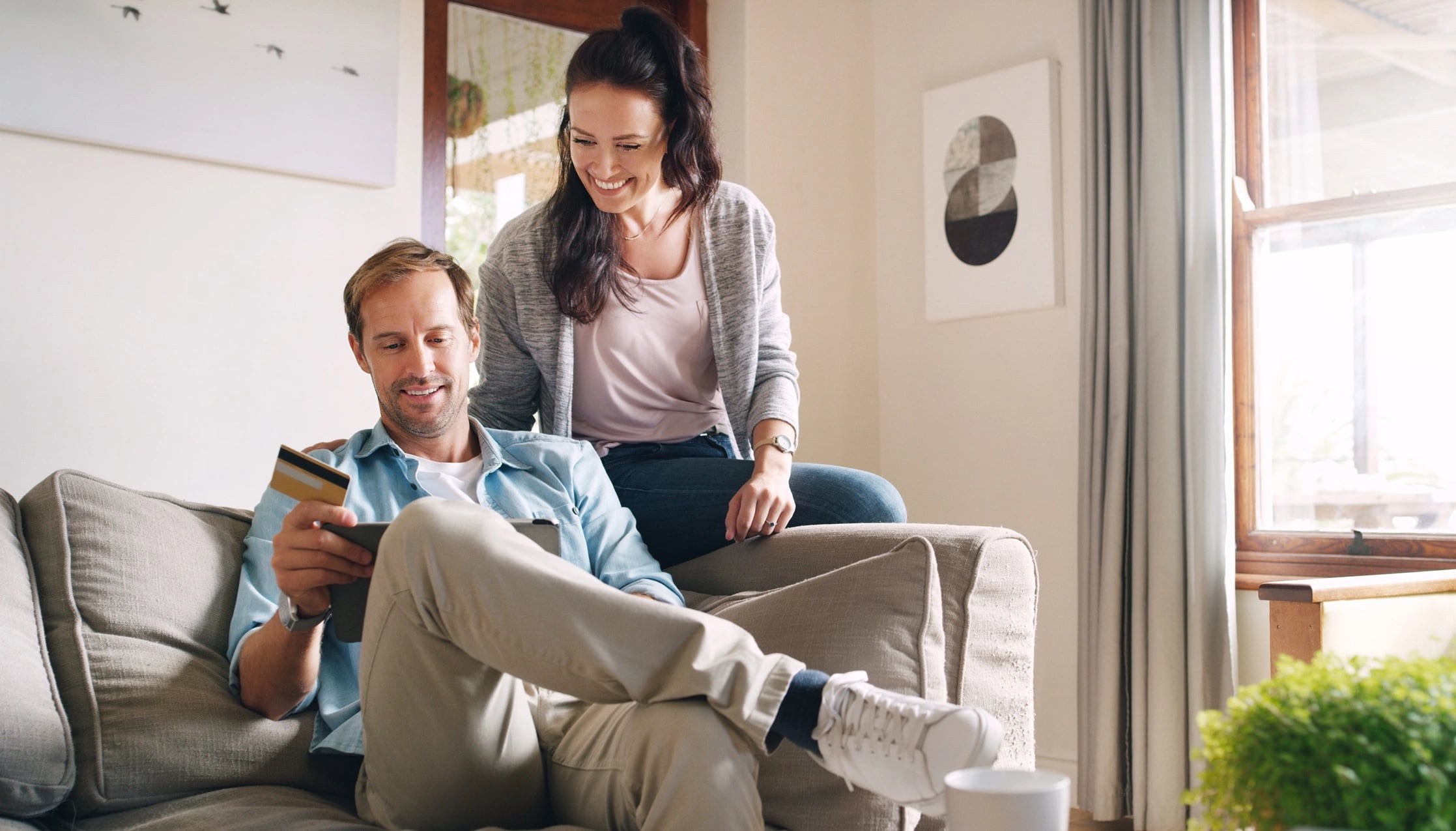 Two people at home reviewing the OMC Health online medical certificate process on a smartphone
