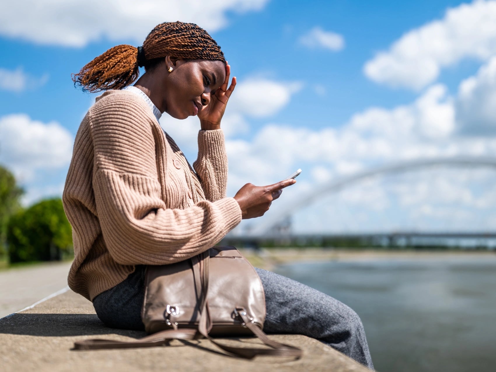 Woman checking her phone for an online medical cancellation letter request from OMC Health in Australia.