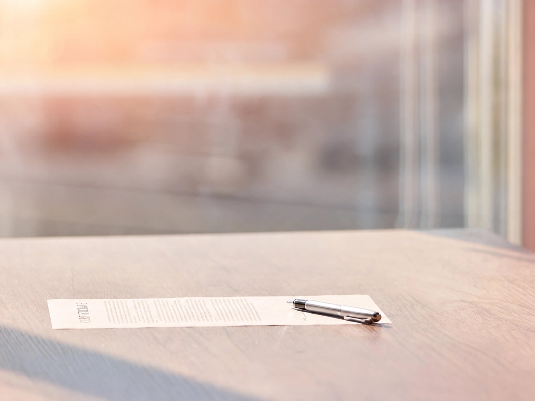 Lone document and pen resting on a sunlit desk, reflecting the legal risk of a fake medical certificate.
