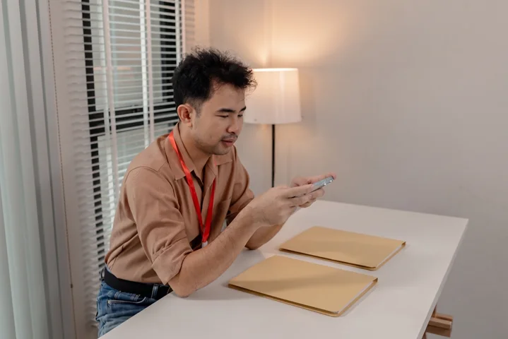 Tradesperson reviewing two documents and their phone for a WorkCover Certificate of Capacity in WA and SA